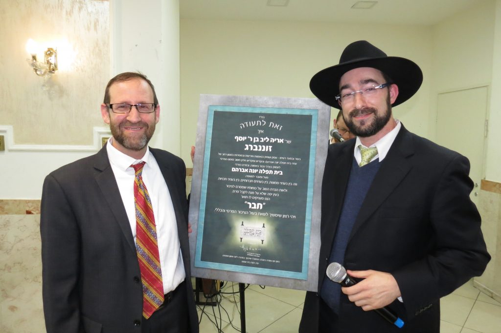 Dovid Kallus presenting Aryeh Sonnenberg with a "Chaver" award at the BTYA Melaveh Malkah